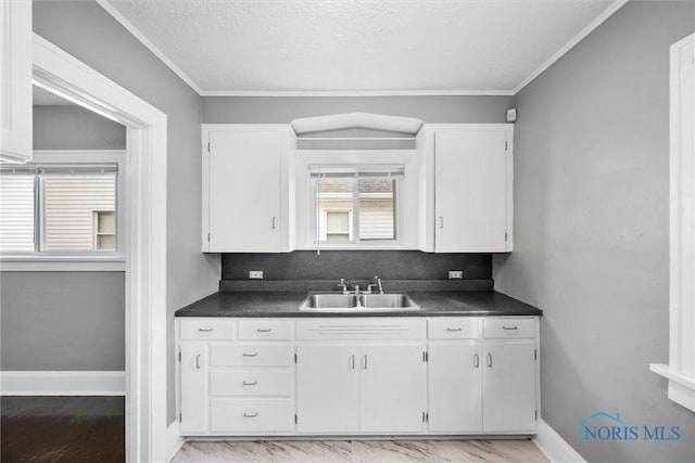 kitchen with white cabinets, a sink, and dark countertops