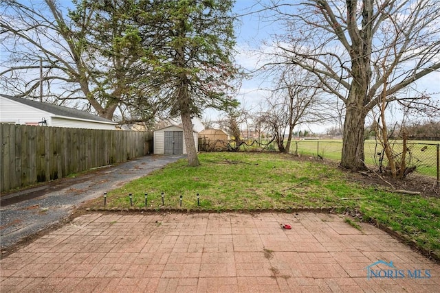 view of yard featuring a fenced backyard, an outbuilding, and a storage shed