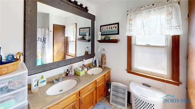 full bath featuring double vanity, walk in shower, and a sink