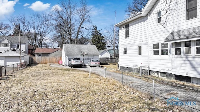 view of yard with an outbuilding, fence, a garage, and a residential view