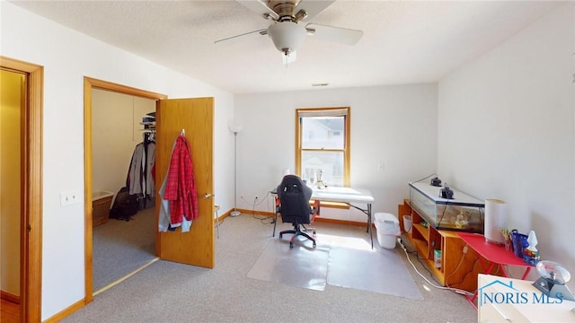 carpeted home office with baseboards, a textured ceiling, and ceiling fan