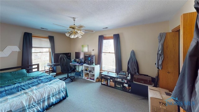 bedroom with multiple windows, carpet floors, a textured ceiling, and visible vents