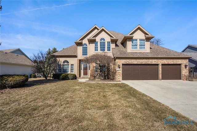 traditional-style home with brick siding, driveway, an attached garage, and a front yard