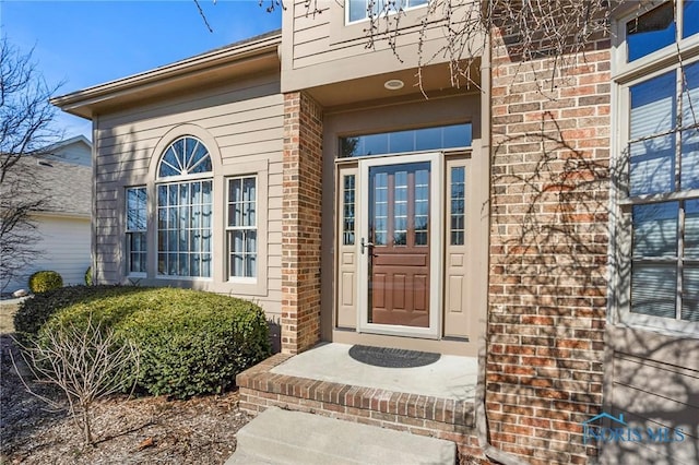 view of exterior entry featuring brick siding