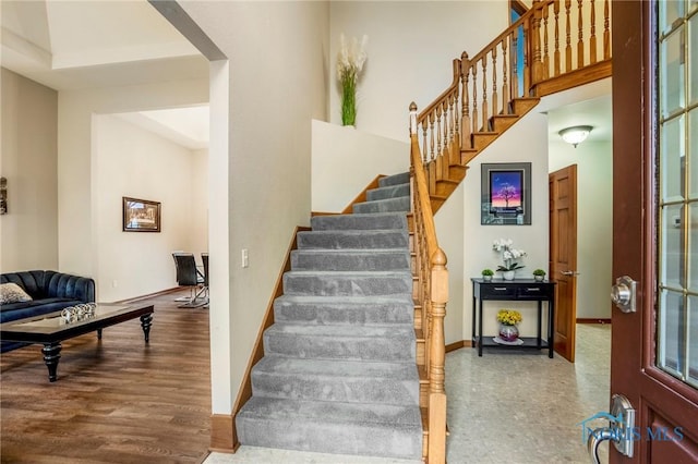 staircase featuring wood finished floors and baseboards