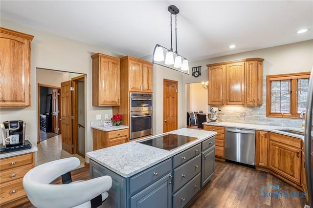 kitchen featuring dark wood-style floors, a kitchen island, stainless steel appliances, pendant lighting, and backsplash