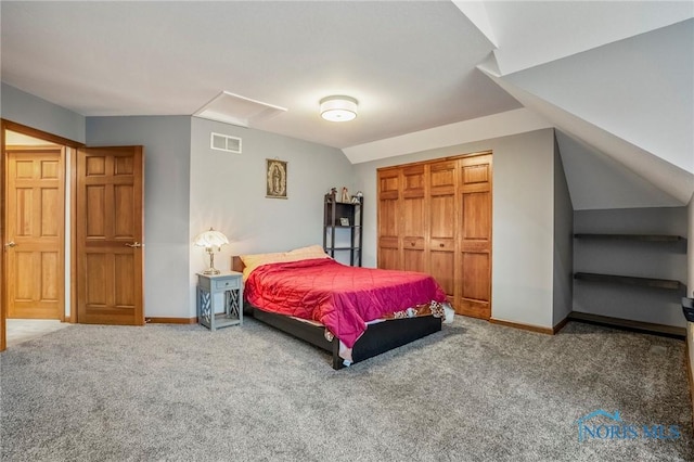 carpeted bedroom with a closet, visible vents, baseboards, and vaulted ceiling