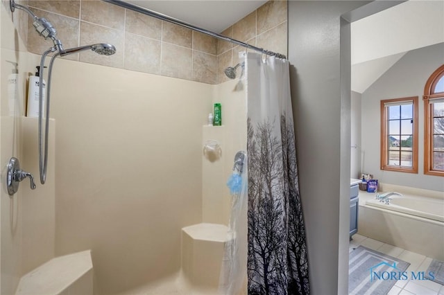 bathroom with tile patterned floors, a stall shower, a garden tub, and vaulted ceiling