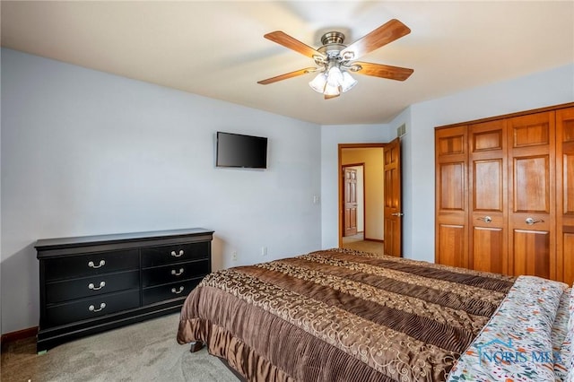 bedroom with a closet, light carpet, visible vents, and a ceiling fan