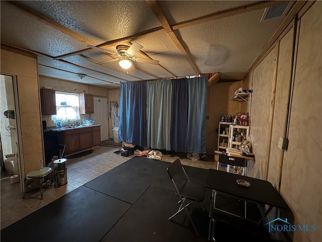 miscellaneous room with visible vents, a textured ceiling, and ceiling fan