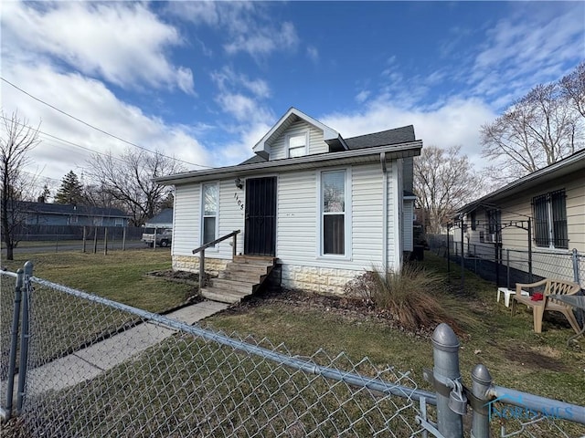 view of front facade with a gate, a fenced front yard, a front lawn, and entry steps