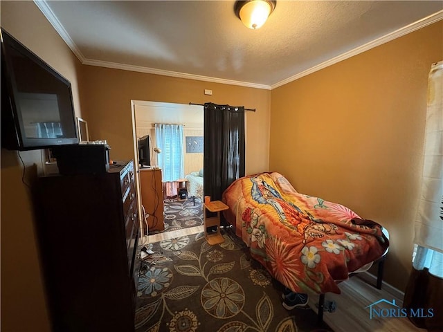 bedroom featuring crown molding and wood finished floors