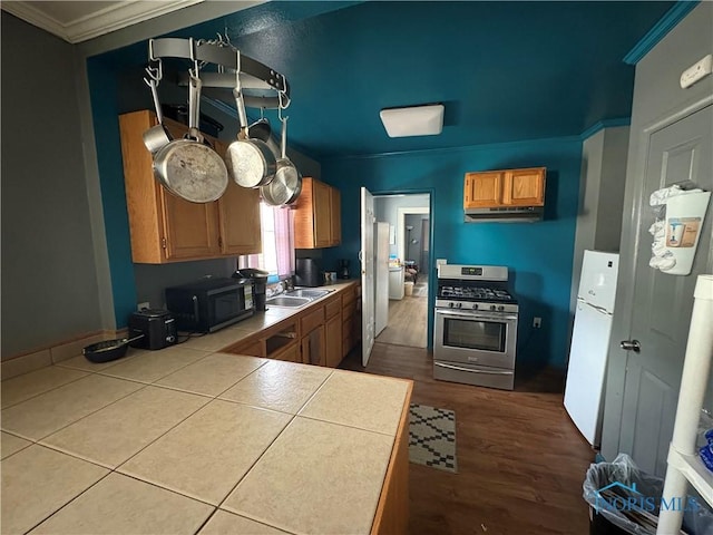 kitchen featuring ornamental molding, a sink, freestanding refrigerator, black microwave, and gas range