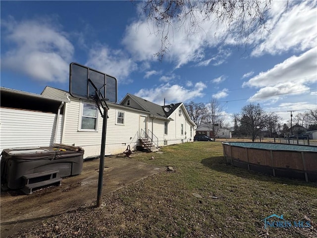 view of yard with entry steps, an outdoor pool, and a hot tub