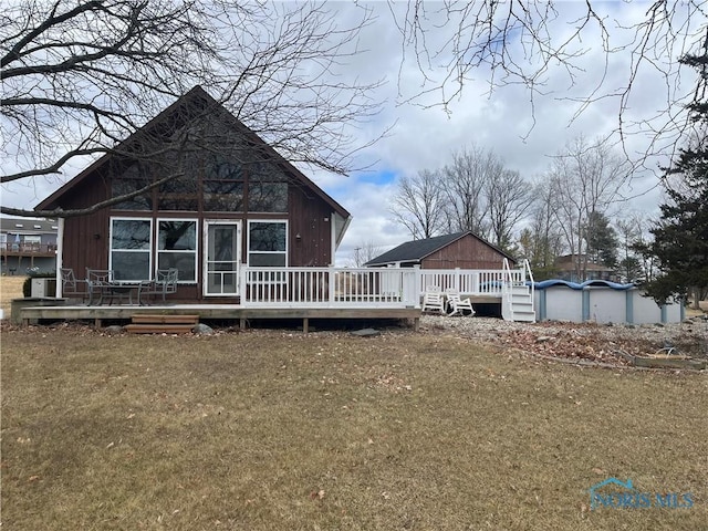 back of house with a lawn and a deck