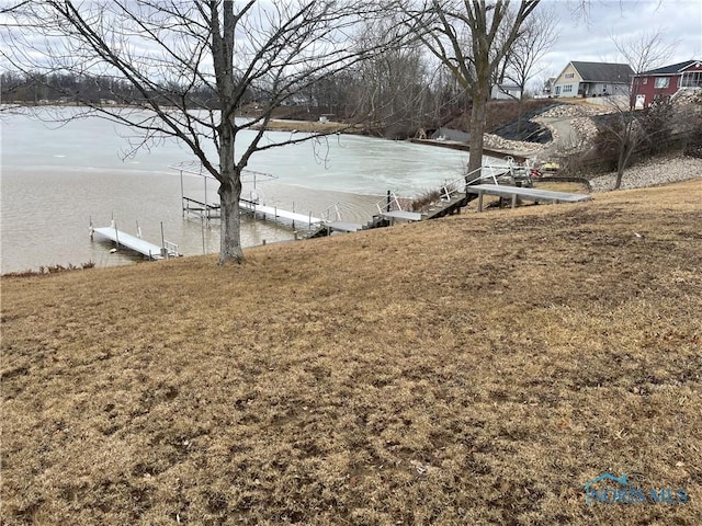 view of yard featuring a dock and a water view