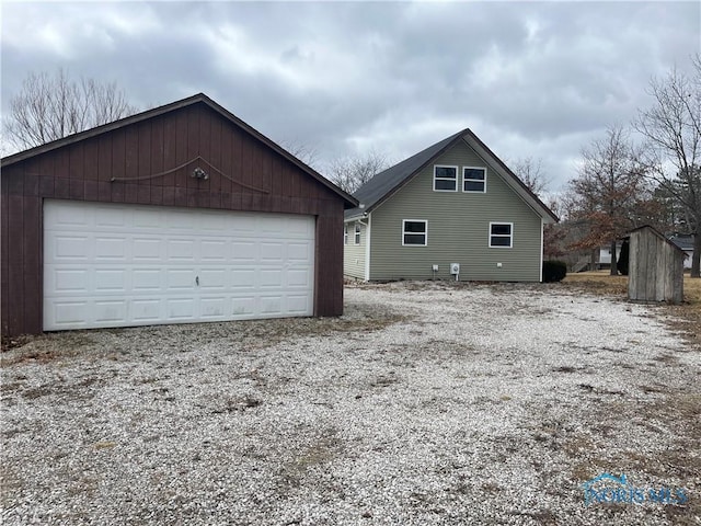 view of property exterior featuring a detached garage and an outdoor structure