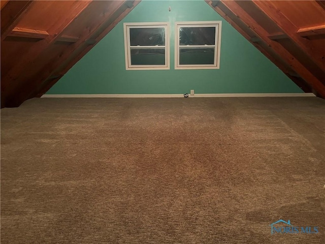 additional living space featuring lofted ceiling and carpet