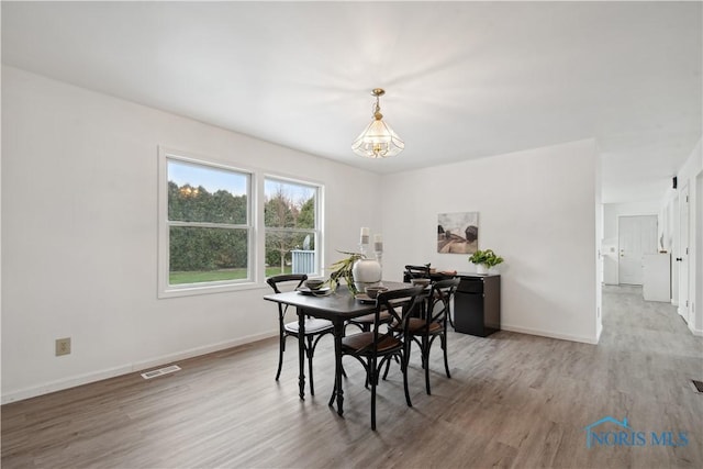 1004 Waterville Monclova Rd, Waterville, OH 43566 - dining area with visible vents, baseboards, an inviting chandelier, and wood finished floors