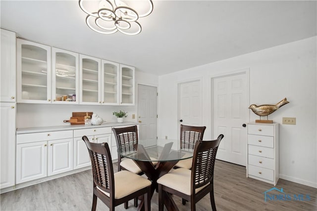 1004 Waterville Monclova Rd, Waterville, OH 43566 - dining room featuring light wood-style flooring, a notable chandelier, and baseboards