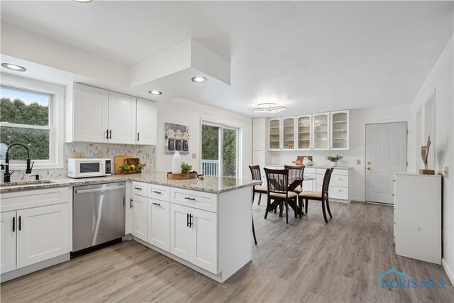 1004 Waterville Monclova Rd, Waterville, OH 43566 - kitchen featuring white microwave, white cabinetry, a peninsula, a sink, and stainless steel dishwasher