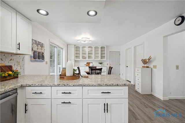1004 Waterville Monclova Rd, Waterville, OH 43566 - kitchen with light stone countertops, a peninsula, white cabinets, stainless steel dishwasher, and light wood-type flooring