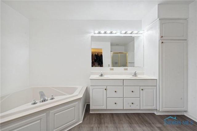 1004 Waterville Monclova Rd, Waterville, OH 43566 - bathroom featuring a sink, a garden tub, wood finished floors, and a shower stall