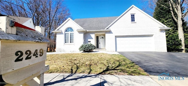 2249 Woods Edge Ct, Toledo, OH 43615 - view of front of property featuring aphalt driveway, an attached garage, and brick siding