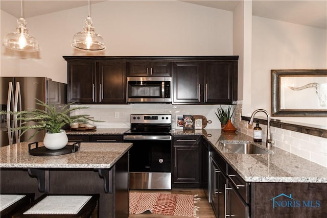 kitchen featuring backsplash, light stone countertops, stainless steel appliances, and a sink