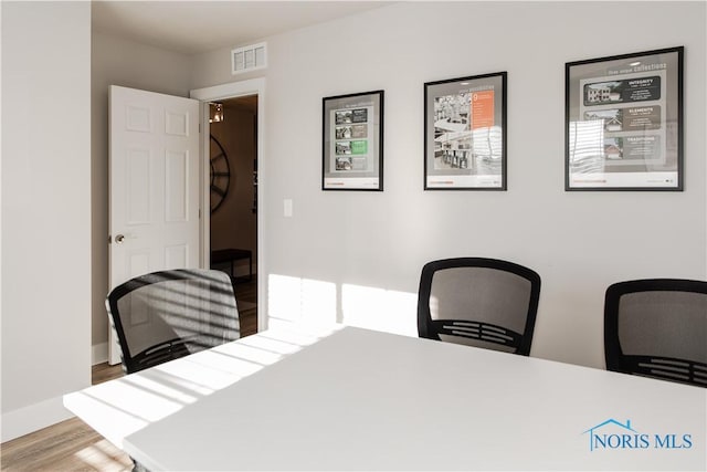 office area featuring visible vents, baseboards, and wood finished floors