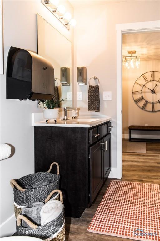 bathroom with vanity, wood finished floors, and baseboards