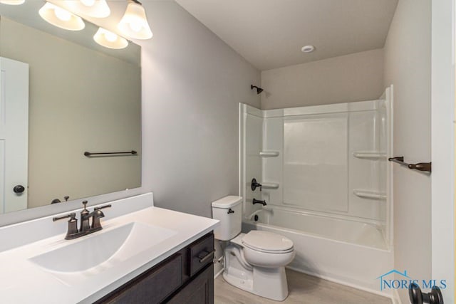 bathroom featuring vanity, toilet, wood finished floors, and shower / bath combination