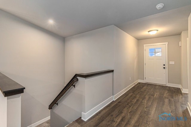 foyer with baseboards and dark wood-type flooring