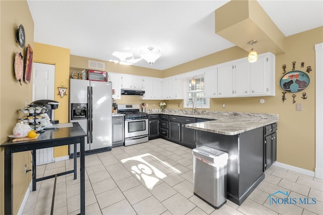 10132 Laplante Rd, Monclova, OH 43542 - kitchen featuring appliances with stainless steel finishes, under cabinet range hood, a peninsula, and white cabinetry