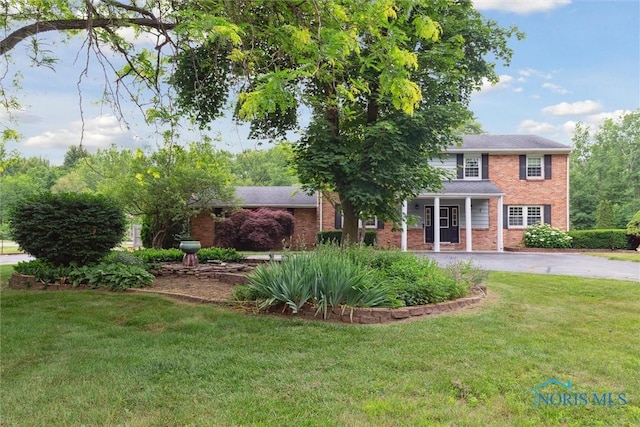 10132 Laplante Rd, Monclova, OH 43542 - view of front facade featuring brick siding, driveway, and a front lawn
