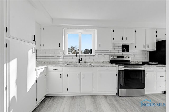 kitchen with white cabinetry, stainless steel range with electric stovetop, light wood finished floors, and a sink