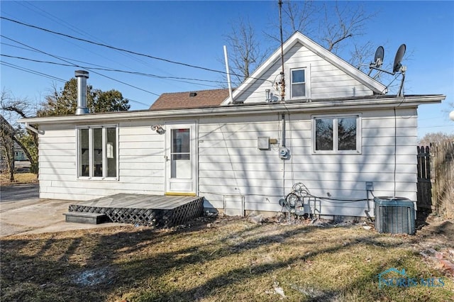 back of house with a yard, a wooden deck, and central AC