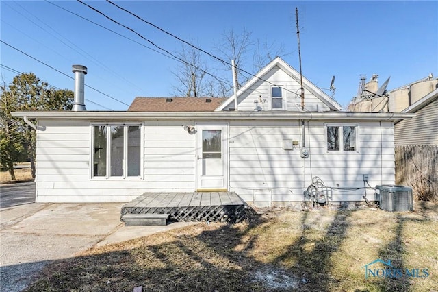rear view of house featuring cooling unit, a wooden deck, and fence