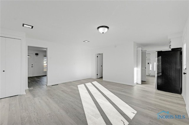 spare room with light wood finished floors and baseboards
