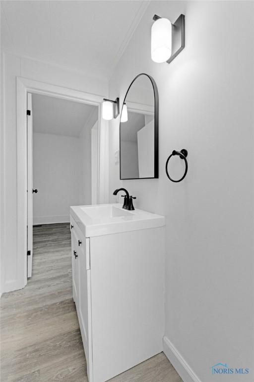 bathroom with vanity, baseboards, and wood finished floors