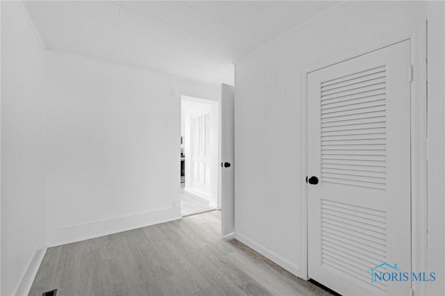 corridor featuring baseboards and wood finished floors