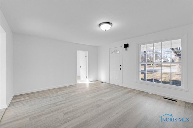 interior space with baseboards, visible vents, and light wood-type flooring