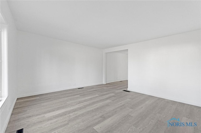spare room featuring visible vents and wood finished floors