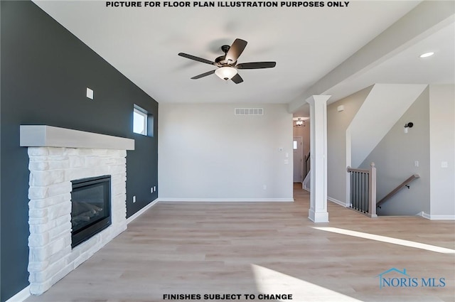 unfurnished living room with visible vents, baseboards, ceiling fan, a stone fireplace, and wood finished floors