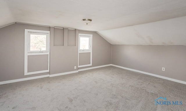 bonus room with carpet flooring, baseboards, and vaulted ceiling