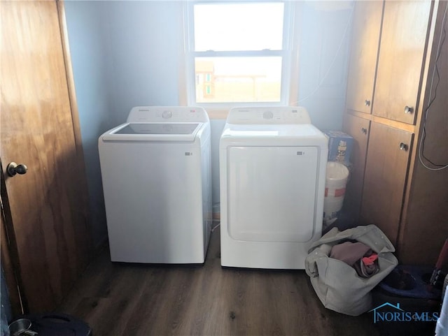 clothes washing area with dark wood finished floors, cabinet space, and independent washer and dryer