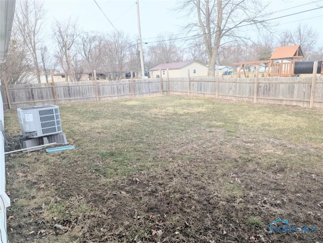 view of yard with a fenced backyard and central AC