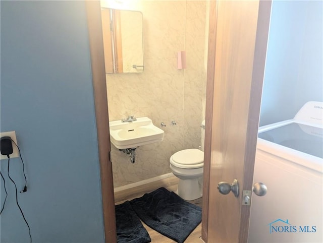 half bath featuring toilet and a sink