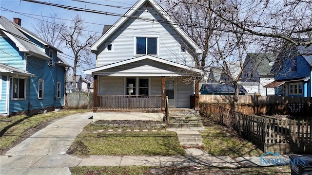view of front of home with a porch and fence