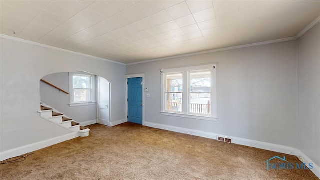 foyer with visible vents, arched walkways, carpet flooring, and crown molding